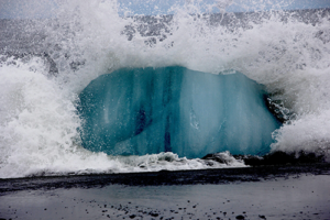 wave impacting ice on a sandy shore